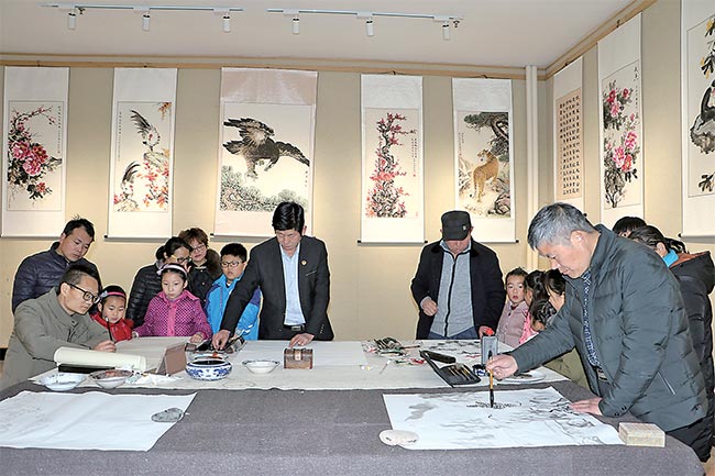 画家现场作画,引来市民驻足观看.本报记者李浩摄