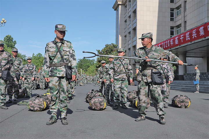 伴随着雄壮的《中国人民解放军军歌》,基干民兵身着迷彩服整齐列队
