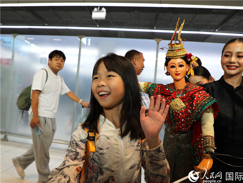 在迎接仪式中，泰国机场工作人员与中国游客友好互动。人民网记者 白元琪摄。