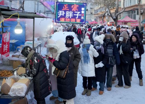 在哈尔滨红专街早市，顾客们排起长队购买油炸糕（1月22日摄）。新华社记者 王毓国 摄